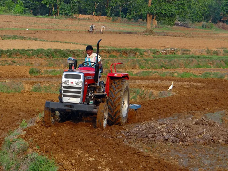 Tractor preparing red soil on a farm block